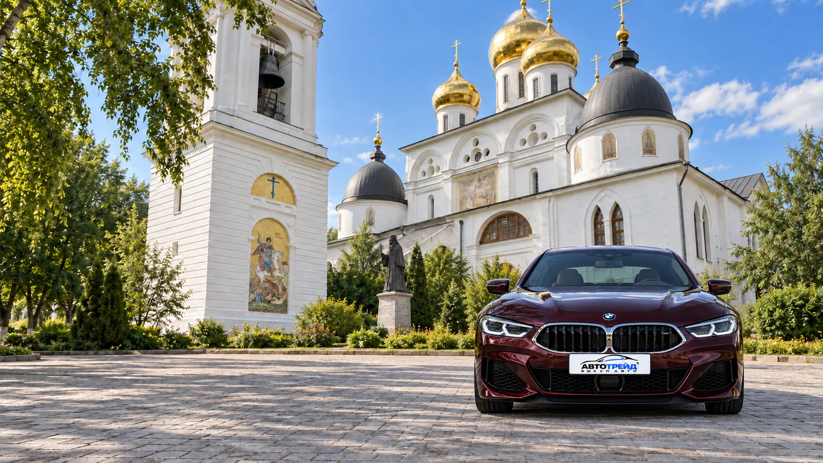 BMW M850i с логотипом Автотрейд на фоне достопримечательности: Успенский собор Дмитровского кремля