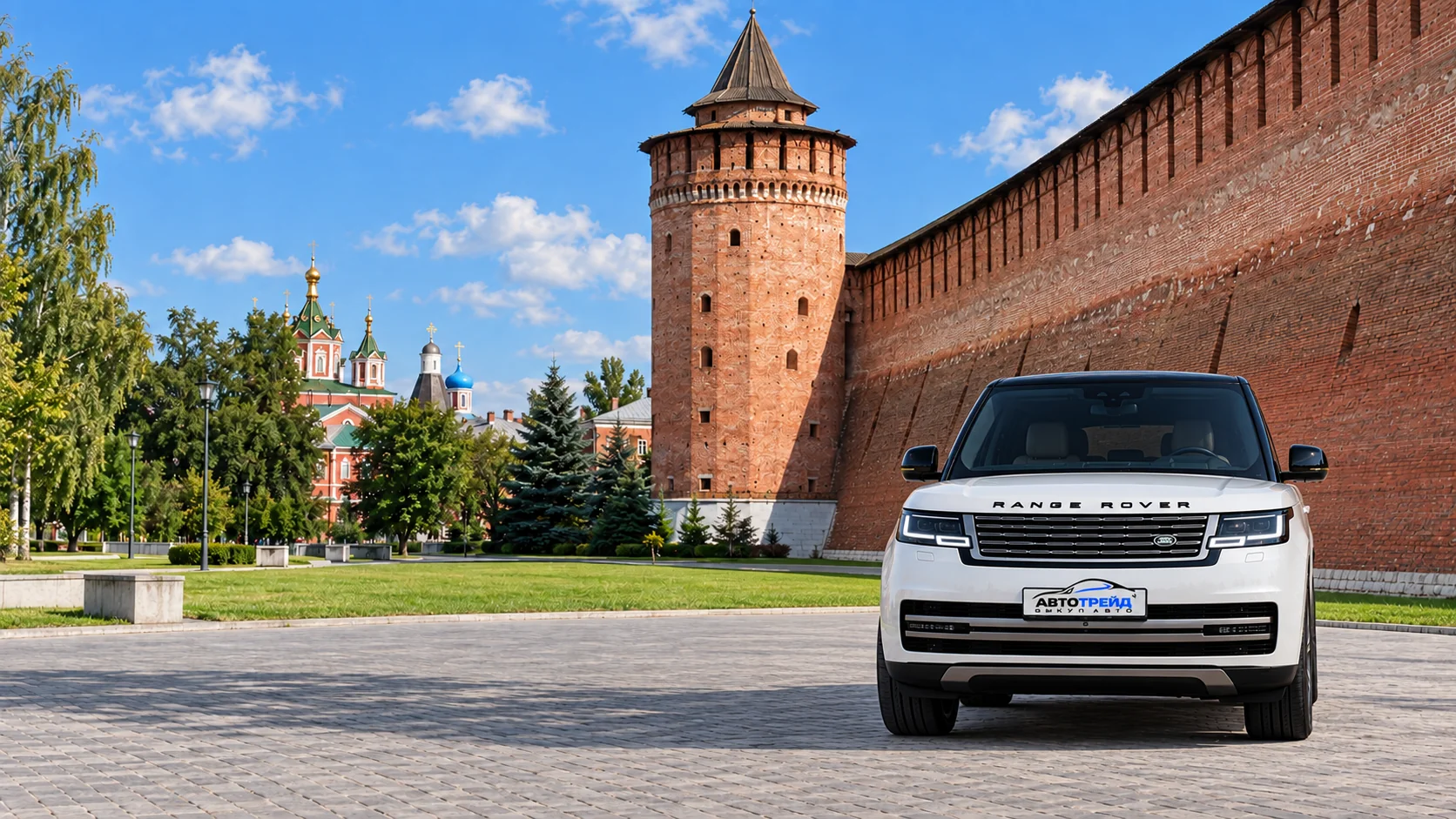 Белый Range Rover с логотипом Автотрейд перед Маринкиной башней и краснокирпичной стеной Коломенского кремля