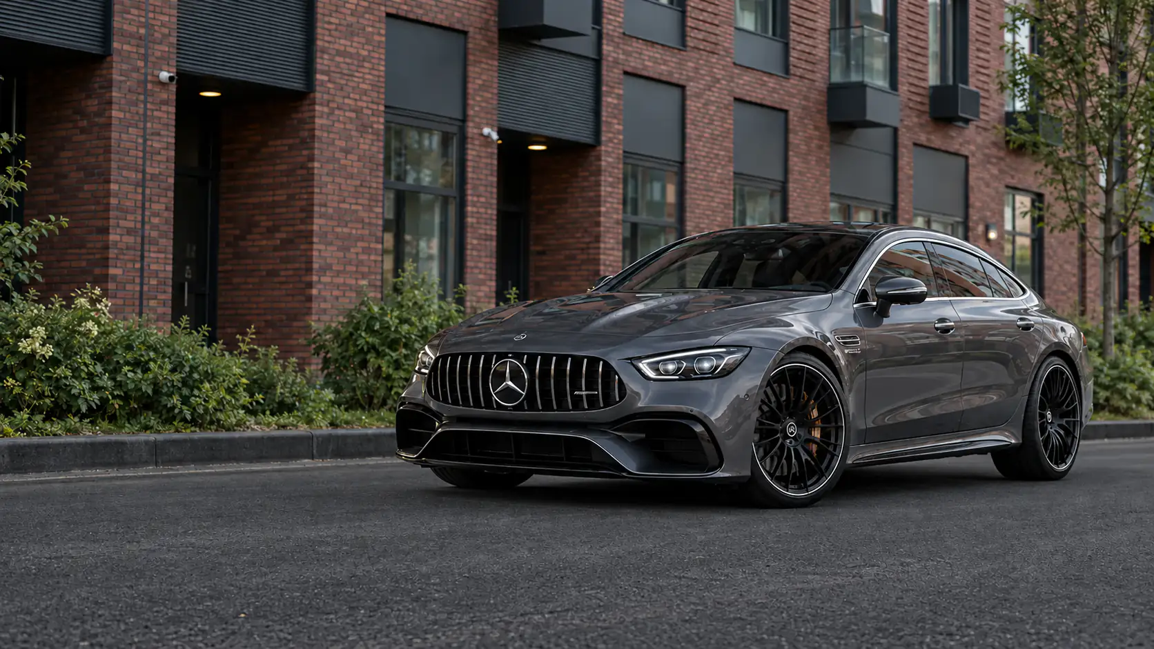 Серый Mercedes-AMG GT у краснокирпичного здания