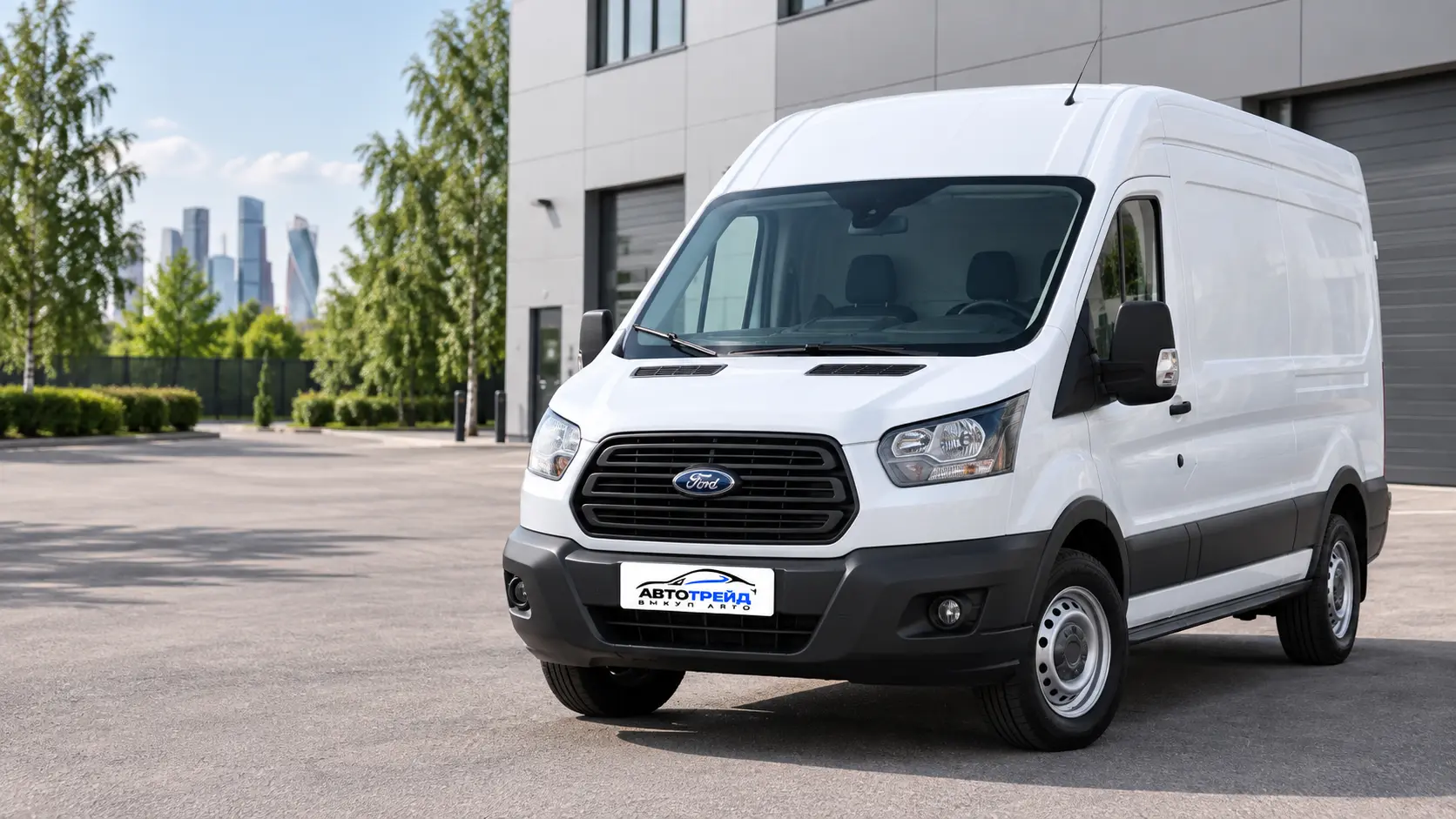 Белый грузовой Ford Transit на площадке у современного здания