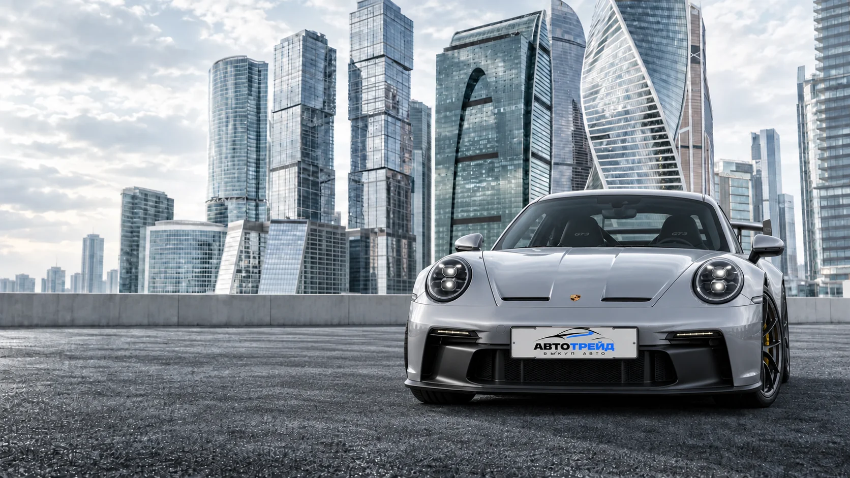 Серебристый Porsche 911 GT3 с табличкой «Автотрейд»