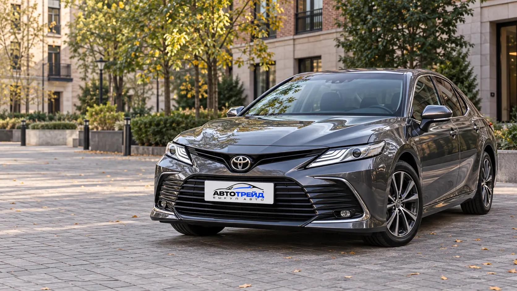 Графитовая Toyota Camry на стоянке в городском дворе